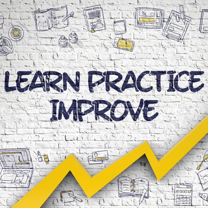 White brickwall with learn practice improve written on it.